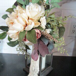 Lantern with floral arrangement and battery operated candle